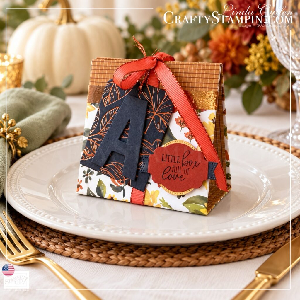 Angled view of a Thanksgiving mini tea box showing its plaid side and decorated floral front on a white plate.