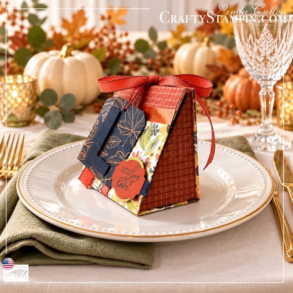 Angled view of a Thanksgiving mini tea box showing its plaid side and decorated floral front on a white plate.