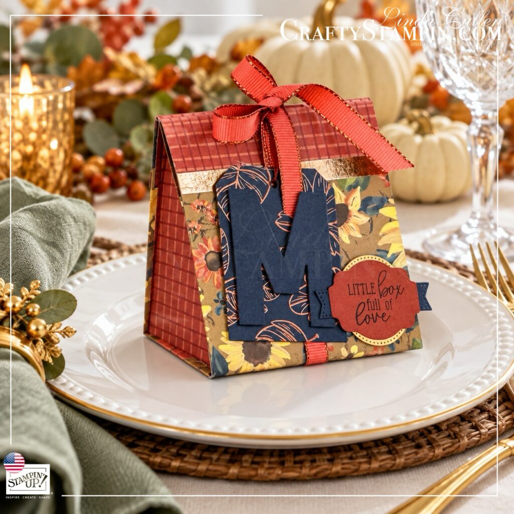Angled view of a Thanksgiving mini tea box showing its plaid side and decorated floral front on a white plate.
